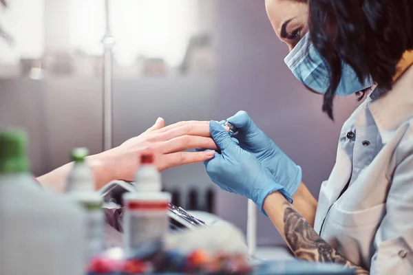 Schoonheidsspecialiste beheersen de procedure trim en verwijderen van de nagelriemen in de schoonheidssalon — Stockfoto