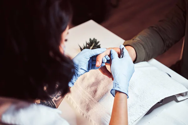 O mestre esteticista faz um procedimento de manicura. Um homem recebendo uma manicure no salão de beleza — Fotografia de Stock