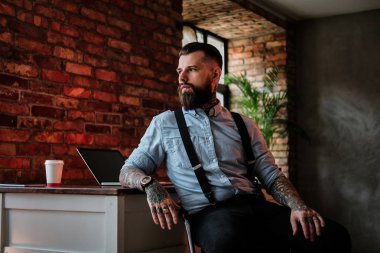 Kollarında tattoes ile sakallı adam portresi