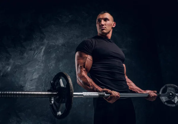 Muskulöser attraktiver Bodybuilder beim Heben einer Langhantel — Stockfoto