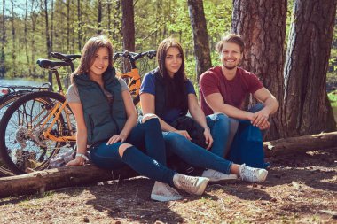 Grup Genç arkadaşlar bisikletleri ile ormana bir güzel yaz günü hiking