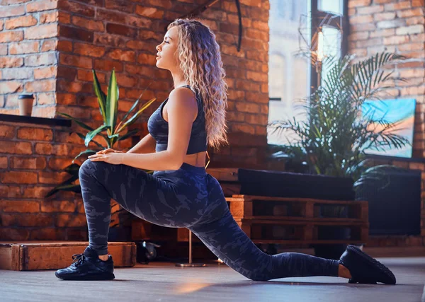 Привлекательная женщина с положительным телом занимается аэробными упражнениями в современном лофте — стоковое фото