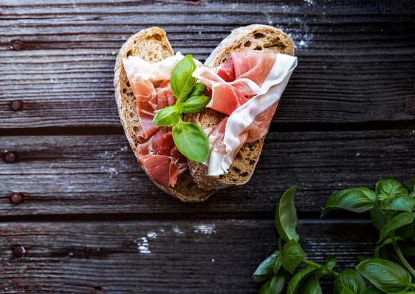 Small sandwiches with meat and basil on the black table. — Stock Photo, Image