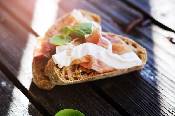 Kleine broodjes met vlees en basilicum op de zwarte tafel. — Stockfoto