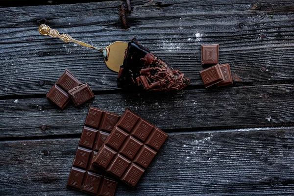 Heerlijk stukje chocoladetaart met stukken of Chocolate op donkere tafel. — Stockfoto