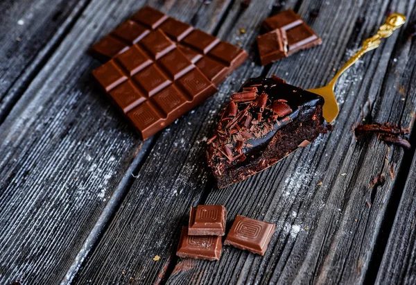 Heerlijk stukje chocoladetaart met stukken of Chocolate op donkere tafel. — Stockfoto