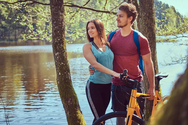 一群年轻的朋友徒步穿越森林与自行车在一个美丽的夏天天 — 图库照片