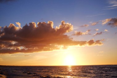 Sakin sahil de derin turuncu gün batımı