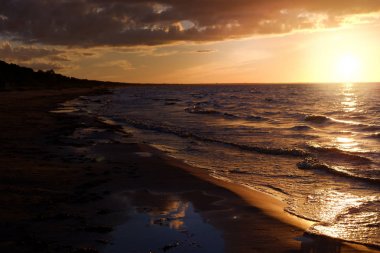 Sakin sahil de derin turuncu gün batımı