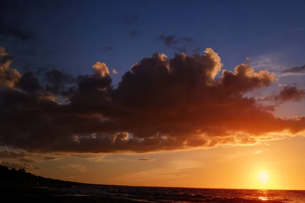 Pôr do sol escuro com sol, mar, nuvens e tons de laranja — Fotografia de Stock