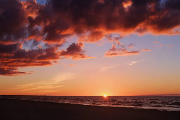 Pôr-do-sol, mar calmo e nuvens coloridas à beira-mar no entardecer — Fotografia de Stock