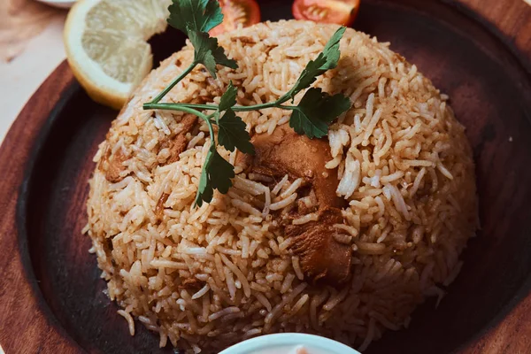 Крупный план индийского традиционного блюда с рисом, лимоном, овощами и кориандром — стоковое фото