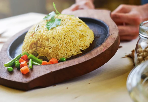 Riso tradizionale indiano al curry con foglia di prezzemolo e verdure su piatto di legno — Foto Stock