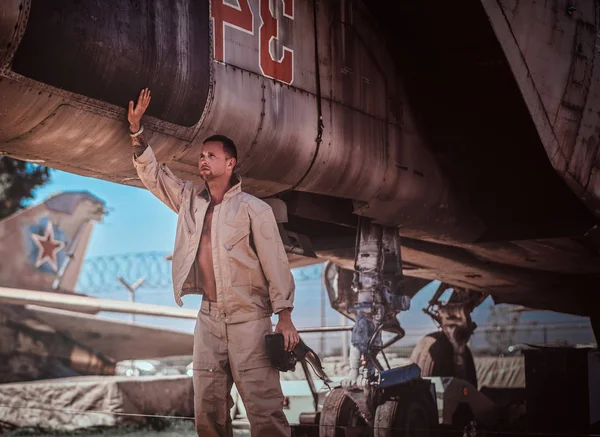 Молодой человек наклоняется к самолёту — стоковое фото
