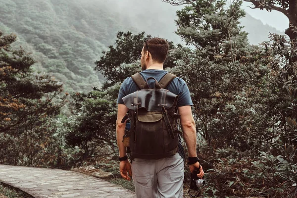 Man with backpack is walking by the stone path in the beautiful nature — Stock Photo, Image