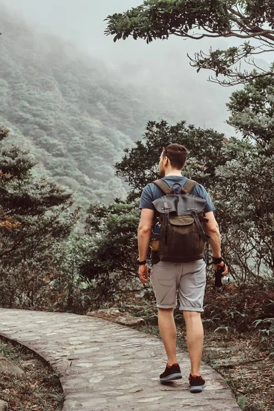 Man med ryggsäck går genom sten stigen i den vackra naturen — Stockfoto