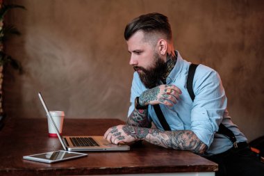 Kollarında tattoes ile sakallı adam portresi