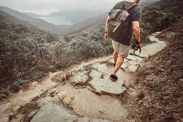 Homem com mochila está andando pelo caminho de pedra na bela natureza — Fotografia de Stock