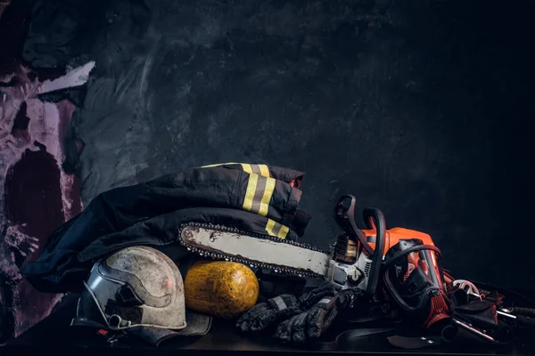 Equipamento de segurança, balão de oxigênio e motosserra na mesa — Fotografia de Stock