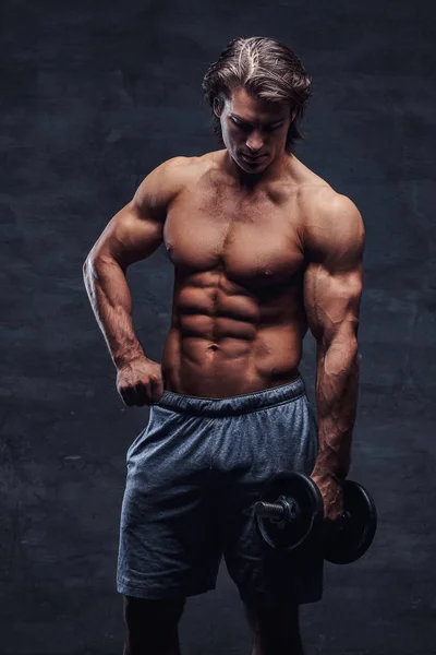 Attractive shirtless bodybuilder is doing exercise with dumbbell — Stock Photo, Image