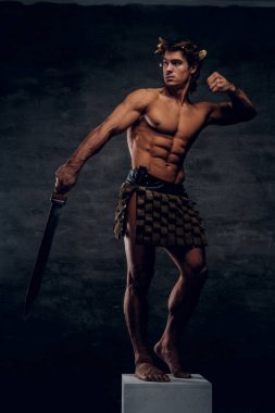 Kılıç ile güzel genç atlet kaide üzerinde poz