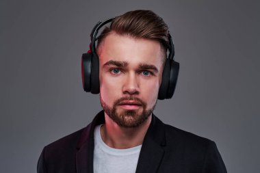 Kablosuz kulaklıklı genç dalgın adam moda müzik dinliyor.