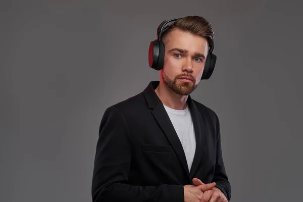 Portrait of attractive young man in wireless headphones which is listening music — Stock Photo, Image