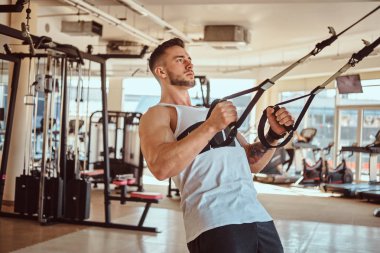 Çekici güçlü vücut geliştirmeci eğitim cihazları üzerinde egzersizler yapıyor