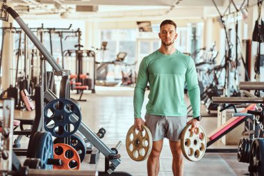 Yeşil eğitim gömlek Sportif çekici adam spor salonunda onun exsercises yapıyor
