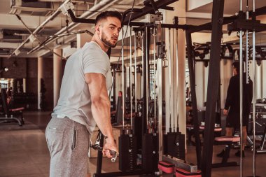 Güçlü güçlü adam eğitim cihazları ile silah için egzersizyapıyor