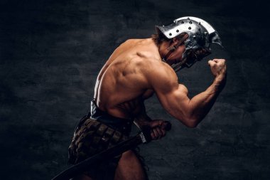 Strong shirtless gladiator in helmet is showing his muscules clipart