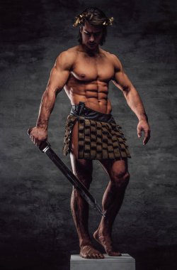 Kılıç ile güzel genç atlet kaide üzerinde poz