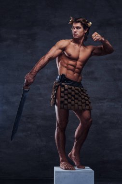 Kılıç ile güzel genç atlet kaide üzerinde poz