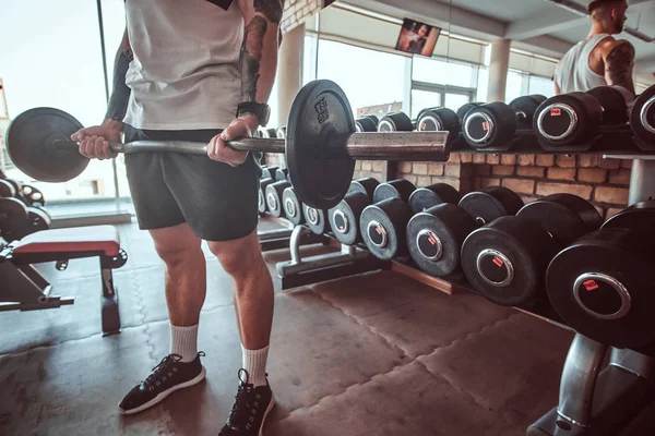Kraftvoller Bodybuilder macht sein Workout mit der Langhantel im Fitnessstudio — Stockfoto