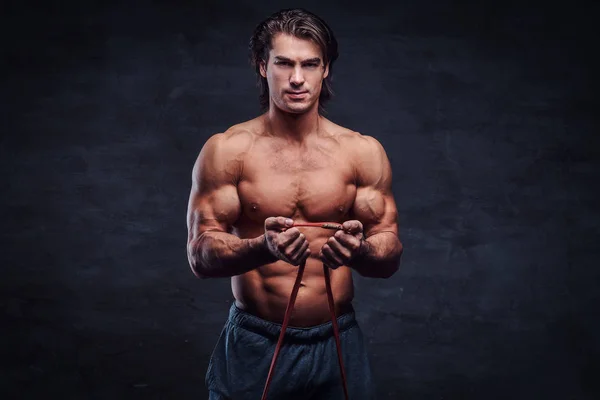 Beautiful smiling bodybuilder is doing exercises with rubber — Stock Photo, Image