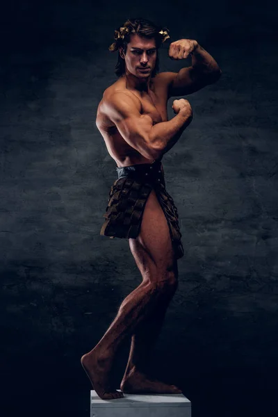 Attractive shirtless man is posing on pedestal and showing his muscules — Stock Photo, Image