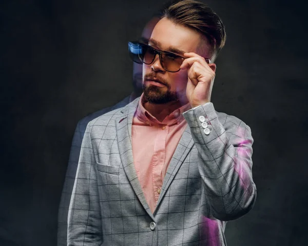 Fotografie přitažlivého chytrého muže v kostře, sluneční brýle a růžová košile. — Stock fotografie