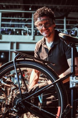 Koruyucu gözlük pensive çalışkan usta atölyede bisiklet sabitleme