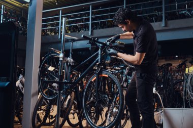 Expirienced genç usta işyerinde müşterilerine bisiklet tamir ediyor
