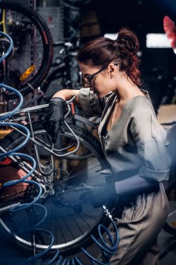 Çekici kadın yoğun atölyede bisiklet tamir.