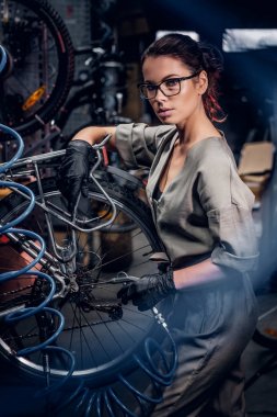 Çekici kadın yoğun atölyede bisiklet tamir.