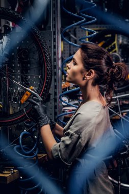 Çalışkan çekici kadın pnömatik teller arasında yoğun atölyesinde bisiklet sabitleme