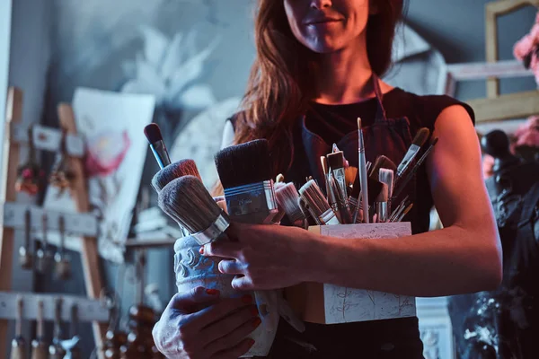 Talentosa pintora posa con pinceles en su propio estudio de arte . — Foto de Stock