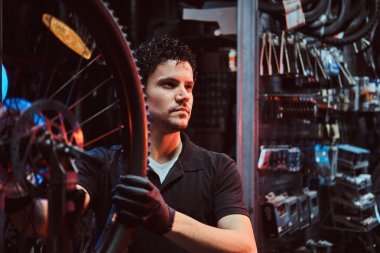 Yakışıklı çalışkan usta işyerinde bisiklet tekerleği sabitleme