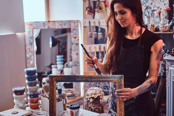 Young talented painter is restourating old frame in her own workshop — 스톡 사진