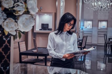 Çekici zarif kadın lüks mücevher butik dergi izliyor