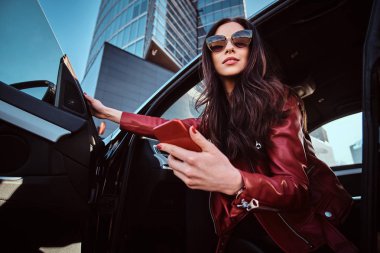 Güzel akıllı kadın cep telefonu sohbet ederken onu yeni arabada poz