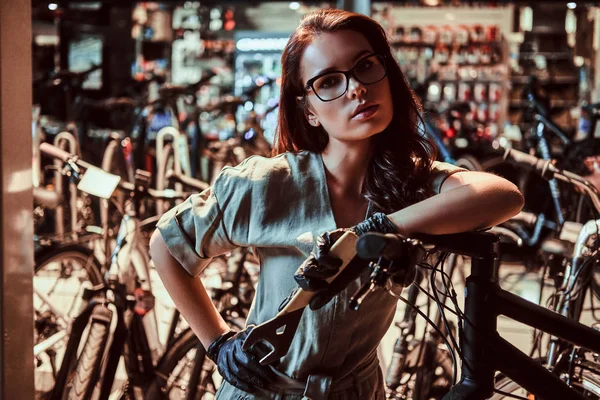 Young attractive worker is chilling after fixing customers bicycle at workshop