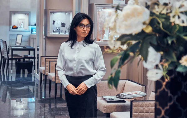 Zarif mücevher butikler asistanı onu lüks dükkanında müşterileri bekliyor