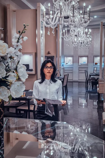 Çekici zarif kadın lüks mücevher butik dergi izliyor